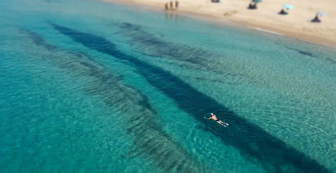 Vue aérienne d'une plage méditerranéenne montrant les zones de courants d'arrachement visibles par la différence de couleur de l'eau