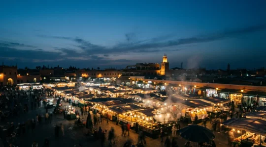 Vue nocturne animée de la place Jemaa el-Fna avec ses stands de nourriture fumants et ses lumières