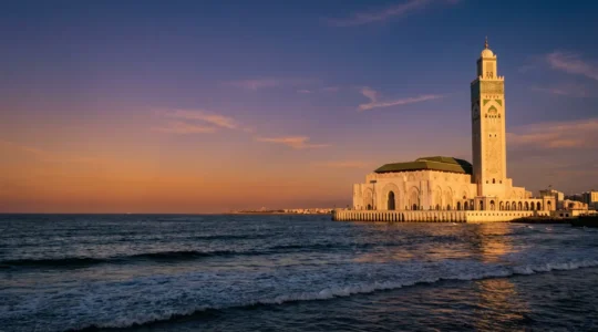 Vue panoramique de la Mosquée Hassan II de Casablanca depuis l'océan Atlantique au coucher du soleil